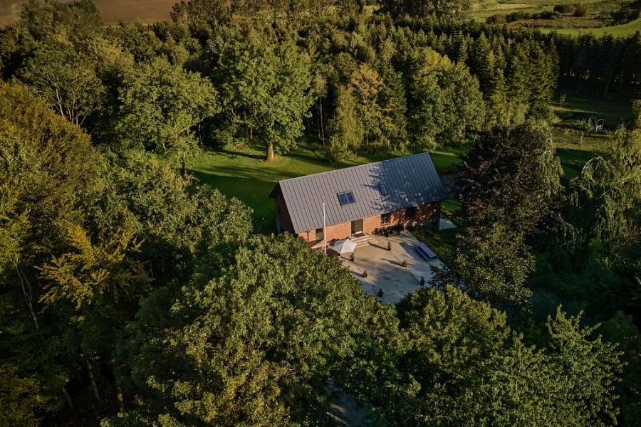 Sommerlys sænker sig over stålprofiler i skoven, Klæstruplundvej 11, 9240 Nibe